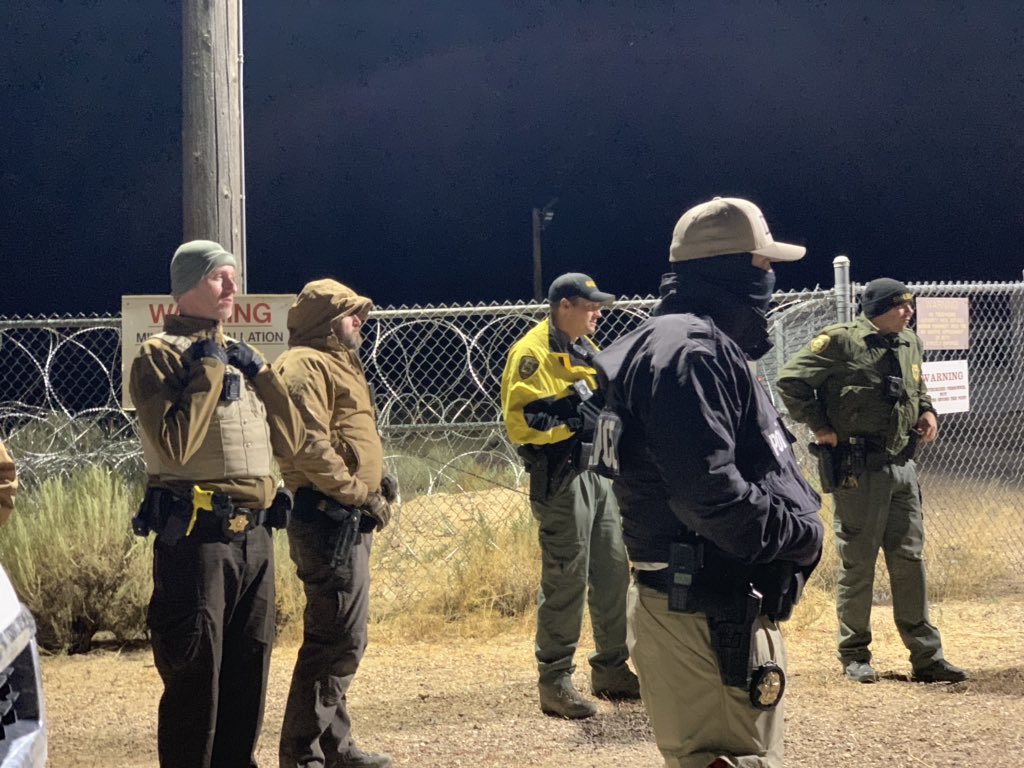 A group of people and law enforcement at the back gate of Area 51 near 3 am. #area51 #StormArea51